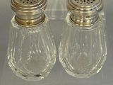 two salt and pepper shakers sitting on a clear table