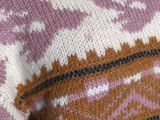 a woman that is wearing a sweater that has a pattern on it