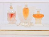 three perfume bottles in a display case on a white surface
