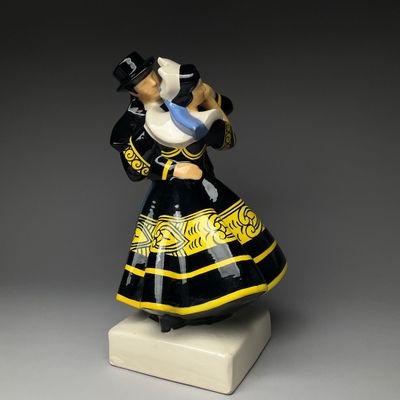 a black and yellow figurine of a woman holding a baby