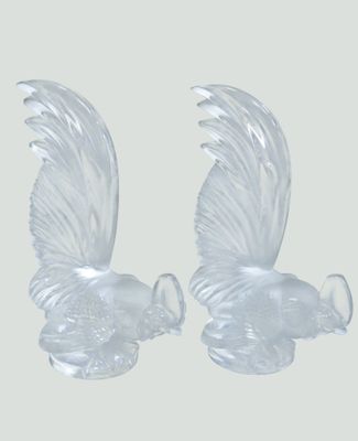deux figurines en verre transparent représentant des oiseaux sur fond blanc