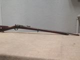 the rifle is sitting on the table next to the wall