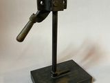 a small metal object on a stand on a white background