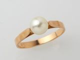a gold ring with a pearl in the center
