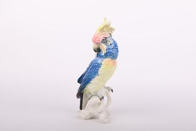 une figurine représentant un perroquet perché sur une branche
