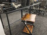 a desk with a chair and a table with a plant on it