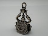 an old silver pocket watch with a chain hanging from it ' s side