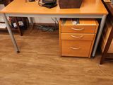 a desk with a computer on it and a basket on top of it
