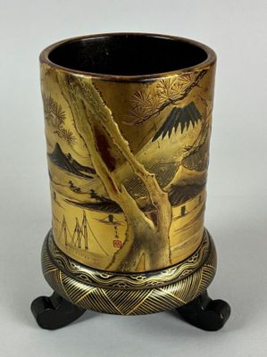 a gold vase with a picture on it on a stand