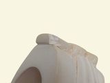 a close up of a white vase on a table