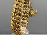 gold plated bracelet with a bird and a green stone on it