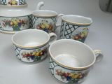 four cups and a teapot sitting on a table