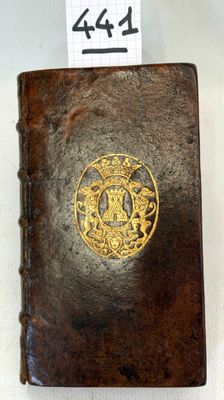 an old leather book with a gold emblem on it