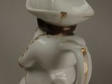 a small white vase with a bird on top of it