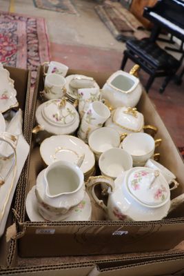 many cups and saucers in a box on the floor