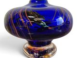 un vase bleu orné d'un oiseau, posé sur un socle