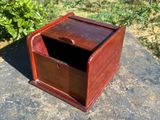 an old wooden box sitting on top of a rock in the grass