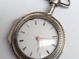 une montre de poche en argent avec des chiffres romains