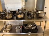 de nombreuses casseroles et poêles posées sur une table en acier inoxydable