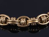 a close up of a gold chain bracelet on a black surface