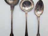 three spoons and a spoon rest on a white surface