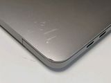 the back of a silver laptop computer sitting on top of a white table