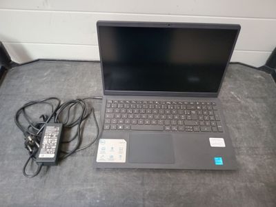 un ordinateur portable posé sur une table et muni d'un chargeur