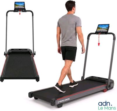 L'homme marche sur un tapis roulant sur lequel est posée une tablette.