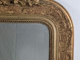 a mirror with a gold frame on a white wall