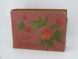 un vieux livre orné de fleurs rouges et de feuilles vertes