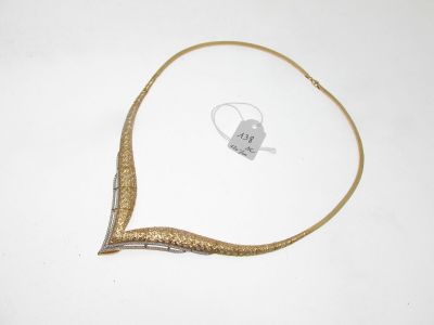 une image représentant un collier en or posé sur une surface blanche