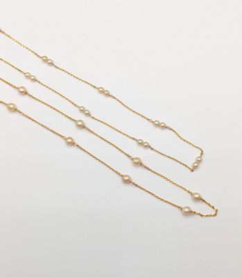 a gold chain necklace with pearls on a white background