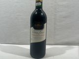 a bottle of red wine sitting on top of a white table
