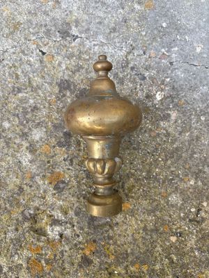 un petit objet en laiton posé sur une surface en béton