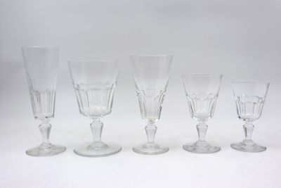 six clear wine glasses lined up in a row on a white surface