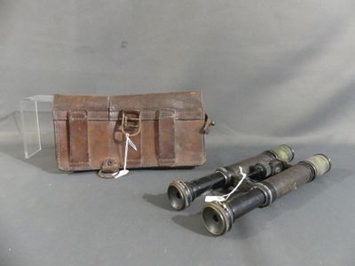 an old pair of binoculars sitting on top of a table next to a leather case