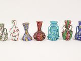 several different colored vases are lined up on a white surface