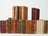plusieurs vieux livres empilés sur une surface blanche