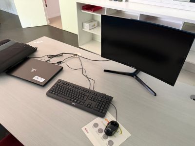 un bureau sur lequel se trouvent un ordinateur portable, un clavier, une souris et un écran