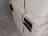 a white cooler sitting on top of the floor next to a wall