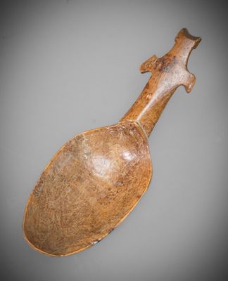 an old wooden spoon with a wooden handle sitting on a table