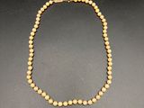 un collier de perles jaunes sur un fond noir