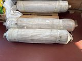 several rolls of cement sitting on top of a pallet in a warehouse