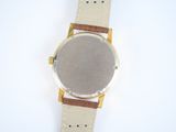 a close up of a watch on a white surface