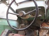 a steering wheel and dashboard of an old green tractor