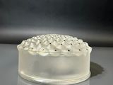 un gâteau blanc posé sur une table, sur fond noir