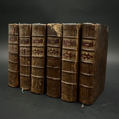 quatre vieux livres sont empilés les uns sur les autres sur une surface noire