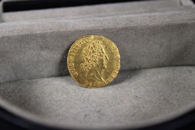 un gros plan sur une pièce d'or dans une boîte posée sur une table