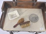 a wooden tray with a brush, soap dish, and soap dish on it