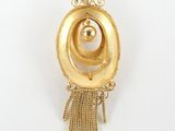 a close up of a gold pendant with a ball in the center